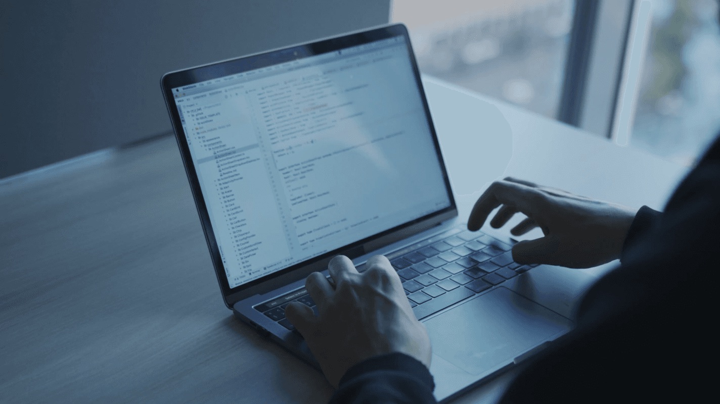 Hands typing on a laptop running business automation software